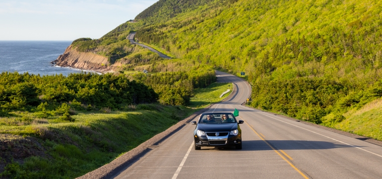 a convertible drives the Cabot Trail