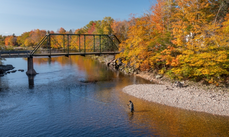 An angler fishes for salmon at the Ross Bridge along the Margaree River in the fall.