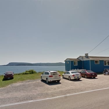 Cars parked outside a restaurant overlooking the ocean