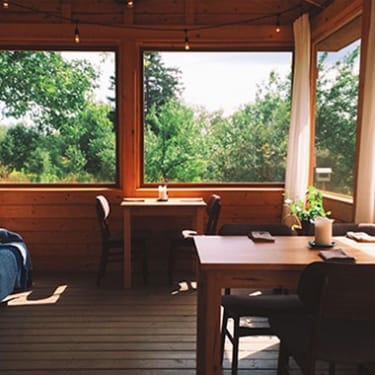 The interior of a sun room with a couch and two tables
