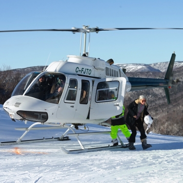 a person exits a helicopter in winter